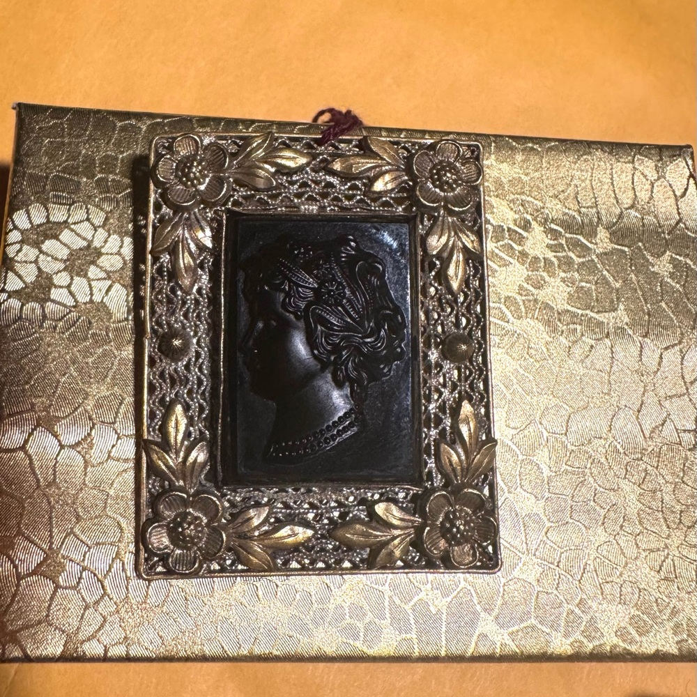 A Czech black glass cameo in gilt brass filigree pin brooch from the 1920s.